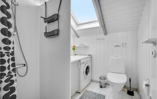 a white bathroom with a toilet and a window at Awesome Home In Hvide Sande With Kitchen in Hvide Sande