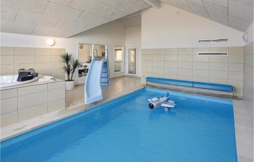 a pool with a slide and a teddy bear laying on the water at Nice Home In Bogense With Kitchen in Skåstrup