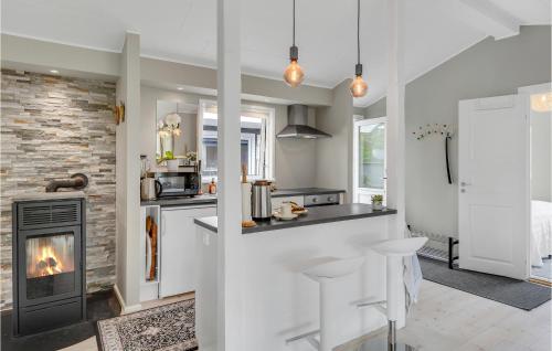 a kitchen with a stove and a fireplace at Beautiful Home In Kirke Hyllinge in Kirke-Hyllinge