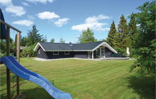 a house with a playground and a slide at Holiday Home Falkevej Idestrup X in Bøtø By