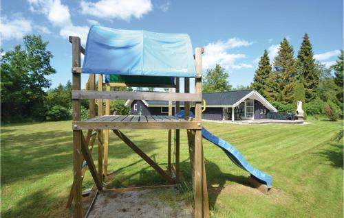a wooden chair with a slide in a yard at Holiday Home Falkevej Idestrup X in Bøtø By