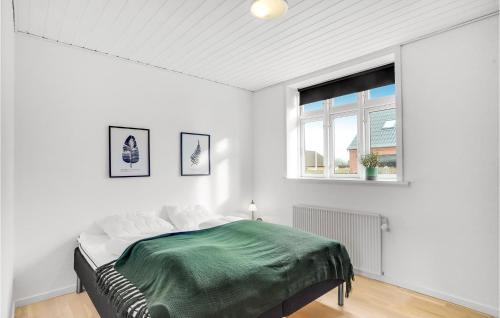 een witte slaapkamer met een bed en een raam bij Cozy Home In Struer With Kitchen in Struer