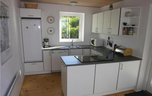 a kitchen with white cabinets and a sink and a window at 4 Bedroom Beautiful Home In Svaneke in Svaneke