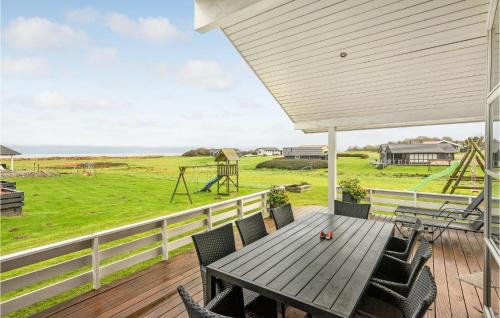 drewniany stół i krzesła na tarasie z placem zabaw w obiekcie Holiday Home Vinkelbæk Nordborg V w mieście Nordborg