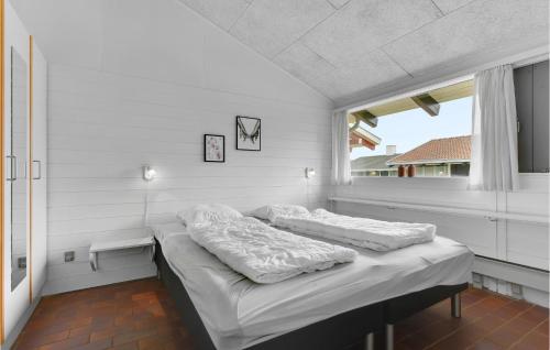 a bed in a white room with a window at Golfparken in Løjt