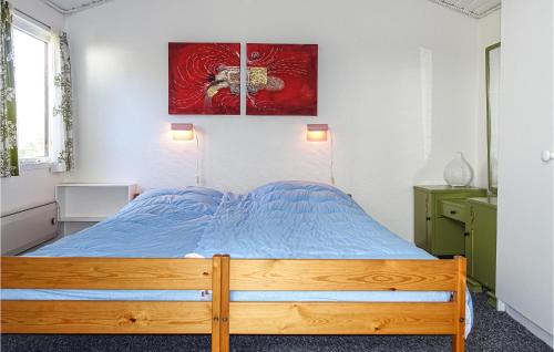 a bedroom with a wooden bed with a blue comforter at 1 Bedroom Beautiful Home In Nex in Neksø