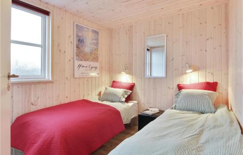 2 Betten in einem Zimmer mit Holzwänden in der Unterkunft Cozy Home In Vejers Strand With Wifi in Vejers Strand