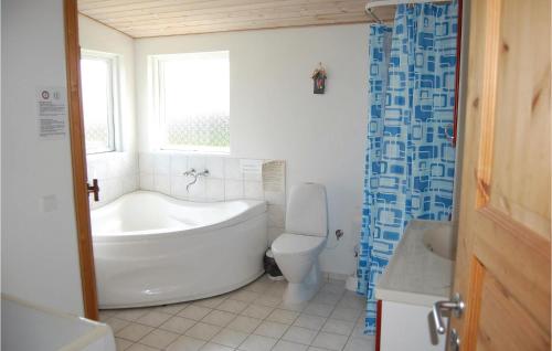 baño con bañera, aseo y ventana en Beautiful Home In Juelsminde With 3 Bedrooms And Sauna, en Sønderby