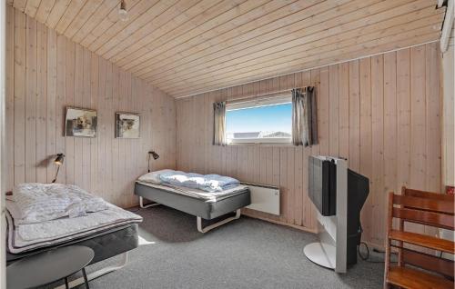 a room with two beds and a television in it at 5 Bedroom Cozy Home In Hvide Sande in Havrvig