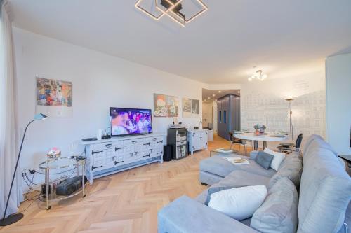 uma sala de estar com um sofá e uma televisão em Dandy House Few Min From Lake - Happy Rentals em Lugano
