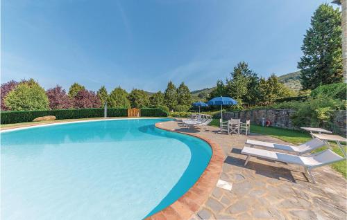 a large swimming pool with chairs and an umbrella at Il Marinocchio Di Malatesti in Arezzo