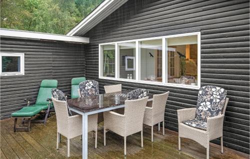 a patio with a table and chairs and a window at Spætten in Bedegård