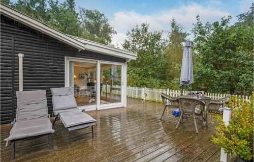 a deck with a table and chairs and an umbrella at Spætten in Bedegård