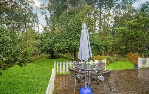 a table and chairs and an umbrella on a deck at Spætten in Bedegård
