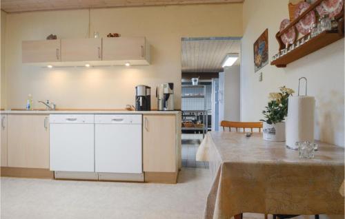 a kitchen with white cabinets and a table in a room at Foldingbro Kro in Lintrup