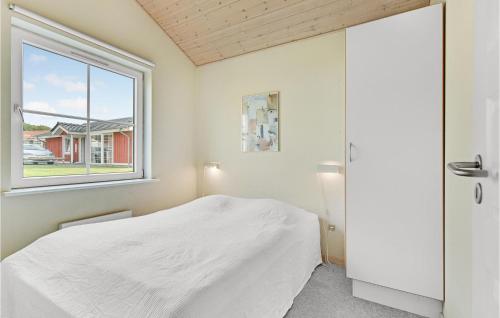 EgernsundにあるMarina Fiskens Ferieparkの白いベッドルーム(ベッド1台、窓付)