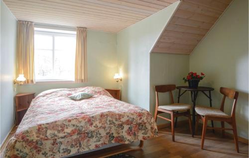 a bedroom with a bed and two chairs and a table at Foldingbro Kro in Lintrup
