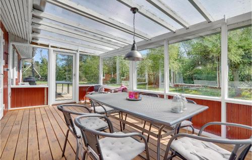 a screened in porch with a table and chairs at Holiday Home Kabbelejevej Væggerløse Ix in Marielyst