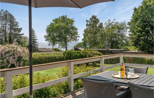 un patio con ombrellone, tavolo e sedie di Holiday Home Fiskervej Ebeltoft Xi a Ebeltoft