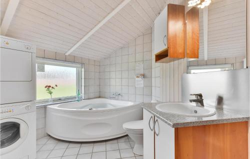 a bathroom with a tub and a sink and a toilet at Awesome Home In Juelsminde With Sauna in Sønderby