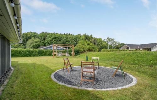 a group of chairs sitting in a yard with a playground at Holiday Home Pøt Strandby Ii Juelsminde I in Sønderby