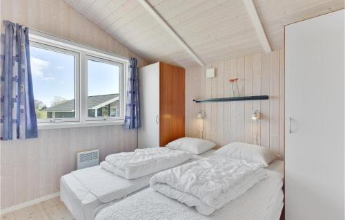 two beds in a room with a window at Awesome Home In Juelsminde With Sauna in Sønderby