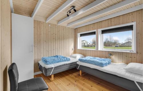 Spodsbjergにある4 Bedroom Lovely Home In Rudkbingのベッド2台 ウッドウォールと窓が備わる客室です。