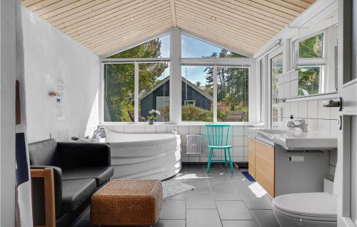 La grande salle de bains est pourvue d'une baignoire et d'un lavabo. dans l'établissement Amazing Home In Ebeltoft With Wifi, à Ebeltoft