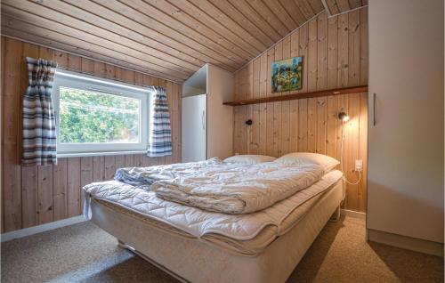 a bedroom with a large bed in a wooden wall at Stunning Home In Ebeltoft With Kitchen in Ebeltoft