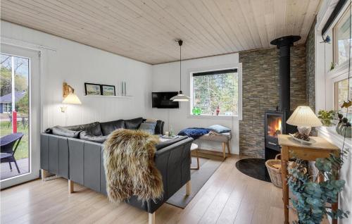 a living room with a couch and a fireplace at Holiday Home Søgårdsvej Ansager in Ansager