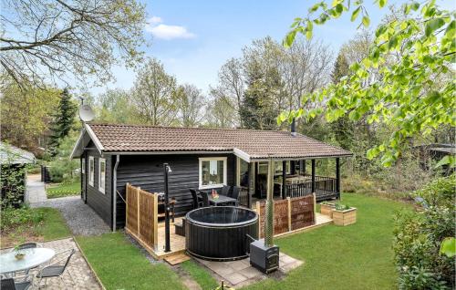 a black tiny house with a hot tub in the yard at Holiday Home Søgårdsvej Ansager in Ansager