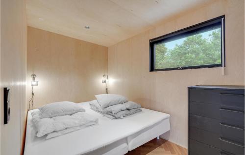 a bedroom with a bed with two pillows and a window at Amazing Home In Knebel With 3 Bedrooms, Wifi And Indoor Swimming Pool in Skødshoved Strand