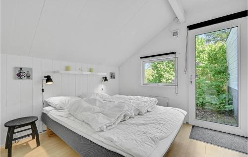 エーベルトフトにあるGorgeous Home In Ebeltoft With House A Panoramic Viewの白いベッドルーム(ベッド1台、窓付)