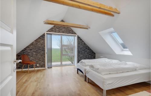 Schlafzimmer im Dachgeschoss mit einem Bett und einem Fenster in der Unterkunft Gorgeous Apartment In Janderup Vestj With Kitchen in Kærup