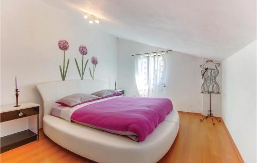 um quarto com uma grande cama branca com lençóis roxos em Nice Home In Dragozetici With House Sea View em Dragozetići