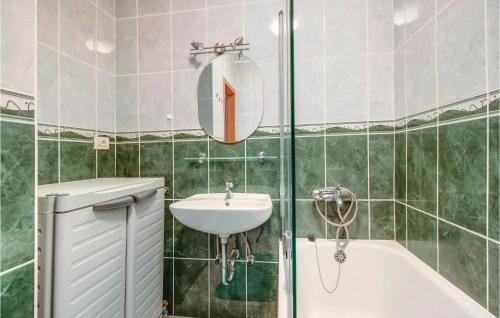 a bathroom with a sink and a tub and a mirror at Beautiful Home In Dragozetici With 3 Bedrooms in Dragozetići