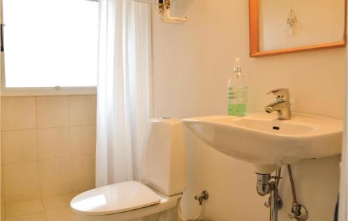 Baño blanco con lavabo y aseo en Awesome Home In Hornbk With 4 Bedrooms And Wifi, en Hornbæk