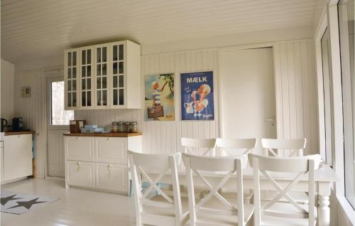 a kitchen with white chairs and a table at Four-Bedroom Holiday Home In Hornbak in Hornbæk