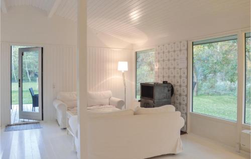 a living room with white furniture and a tv at Four-Bedroom Holiday Home In Hornbak in Hornbæk