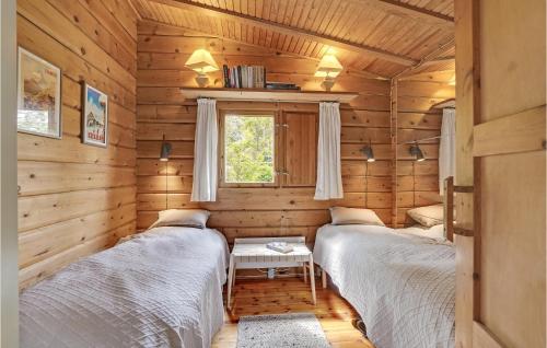 two beds in a log cabin with a window at Cozy Home In Mern With Wifi in Mern