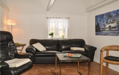a living room with a leather couch and a table at Three-Bedroom Holiday Home In Give in Give