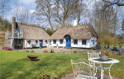 a house with a thatched roof and a table and chairs at Three-Bedroom Holiday Home In Give in Give