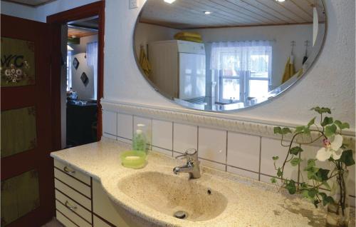 La salle de bains est pourvue d'un lavabo et d'un grand miroir. dans l'établissement Lovely Home In Give With House A Panoramic View, à Give