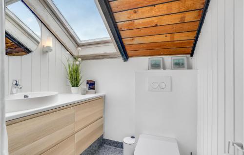 uma casa de banho com um lavatório e um tecto em madeira em 3 Bedroom Beautiful Home In Rm em Bolilmark