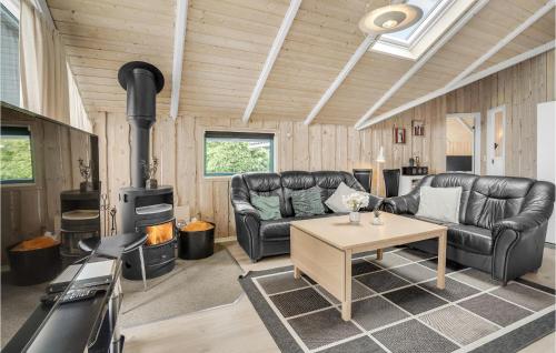 a living room with two leather couches and a stove at Holiday Home Vestertoften in Høruphav