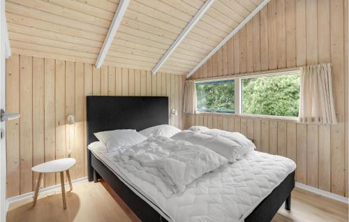 a bedroom with a large bed in a wooden wall at Holiday Home Vestertoften in Høruphav