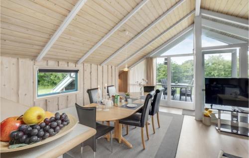 a dining room and living room with a table and chairs at Holiday Home Vestertoften in Høruphav