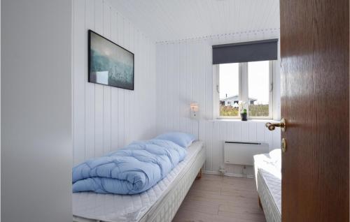 Una habitación con una cama con mantas azules. en Nice Home In Ebberup With 3 Bedrooms And Wifi, en Helnæs By