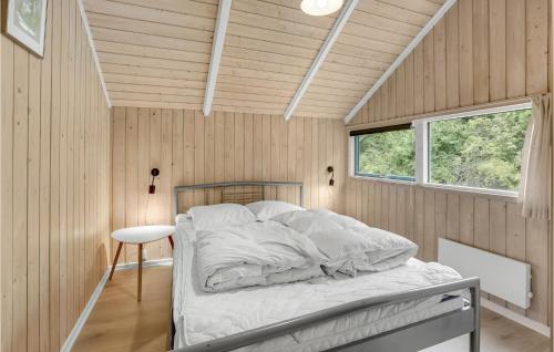 a bedroom with a bed in a room with wooden walls at Pet Friendly Home In Sydals With Wifi in Høruphav