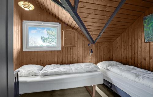 sypialnia z 2 łóżkami w drewnianym pokoju w obiekcie 3 Bedroom Lovely Home In Fan w mieście Fanø
